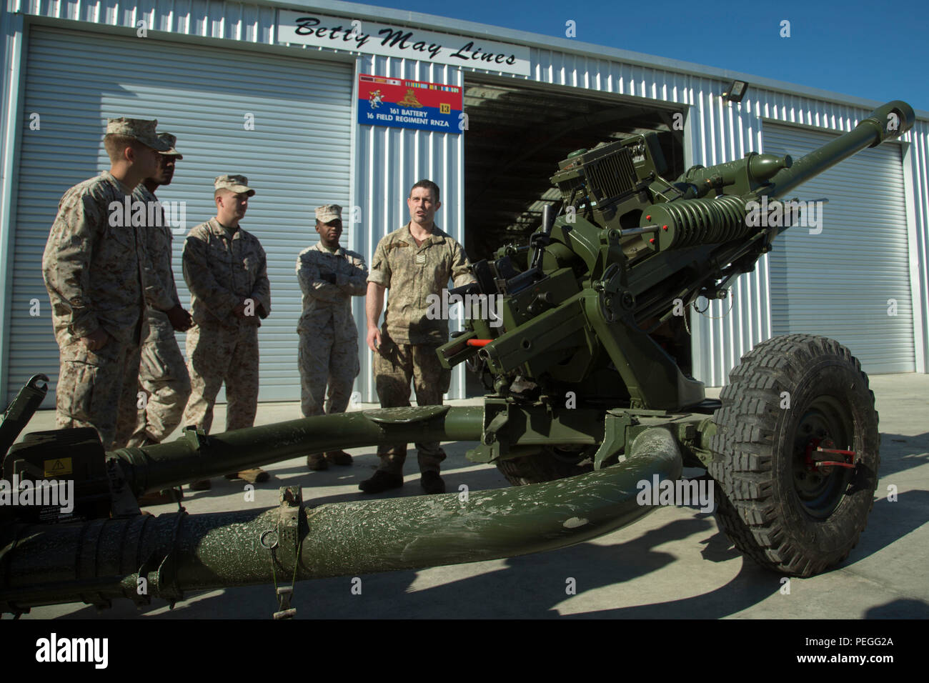 Neuseeland Armee Sgt. Andrew Smith, rechts, zeigt US-Marines einen 105 mm L 118 Light Gun während der Übung Joint Assault Signale Firma Schwarz, 13.08.2015. Die US-Marines bereiten sich auf eine bilaterale Artillerie schießen, indem sich mit Waffen und Verfahren der Neuseeländischen Armee für den Aufruf für Feuer. Smith ist ein Trupp Sergeant und Loslösung Commander mit 161 Batterie, 16 Feld Regiment. Die Marines sind mit 5 Air Naval Geschützfeuer Liaison Firma, III Marine Expeditionary Force Headquarters Group, III MEF. (U.S. Marine Corps Foto von Cpl. Isaac Ibarra/Freigegeben) Stockfoto