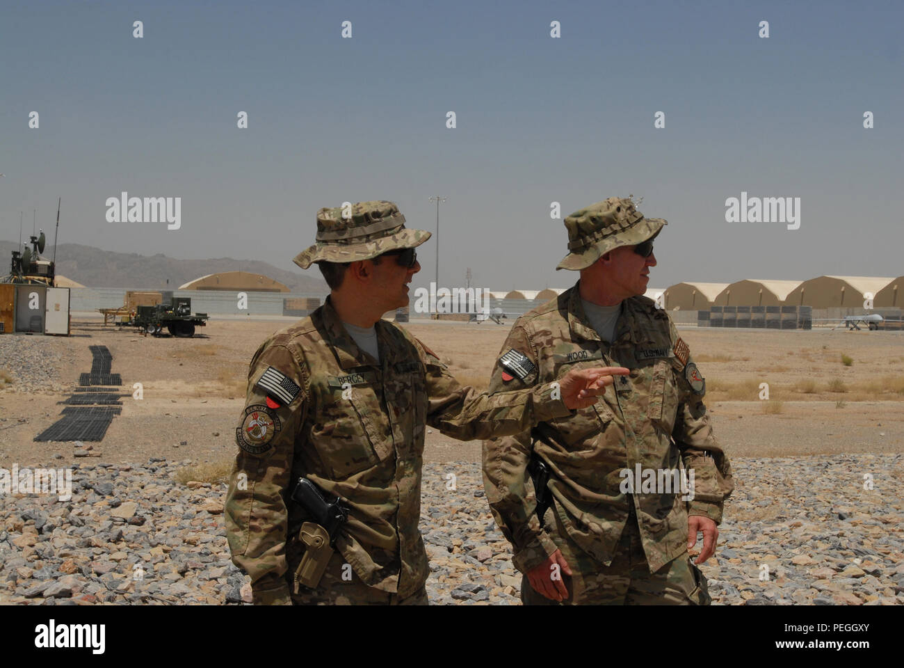 KANDAHAR AIRFIELD, Afghanistan (Aug. 6, 2015) Task Force Copperhead Tactical Unmanned Aerial Vehicle Loslösung US Navy Lieutenant Cmdr. John Bercey, Links, Offizier, und Cmdr. Timothy Wood, Theater Chief, diskutieren die Einführung einer MQ-5B Jäger bei Kandahar Airfield. Bercey und Holz sind als einzelne augmentees und verwenden Sie die MQ-5B ist ein multi-mission UAV mit der Copperhead System gekoppelt, eine Miniatur Synthetic Aperture Radar System, zu erkennen Improvised Explosive Devices mit großem Erfolg auf der NATO-geführten Mission der entschlossenen Unterstützung. (U.S. Marine Foto von Leutnant Kristine Volk/Freigegeben) Stockfoto