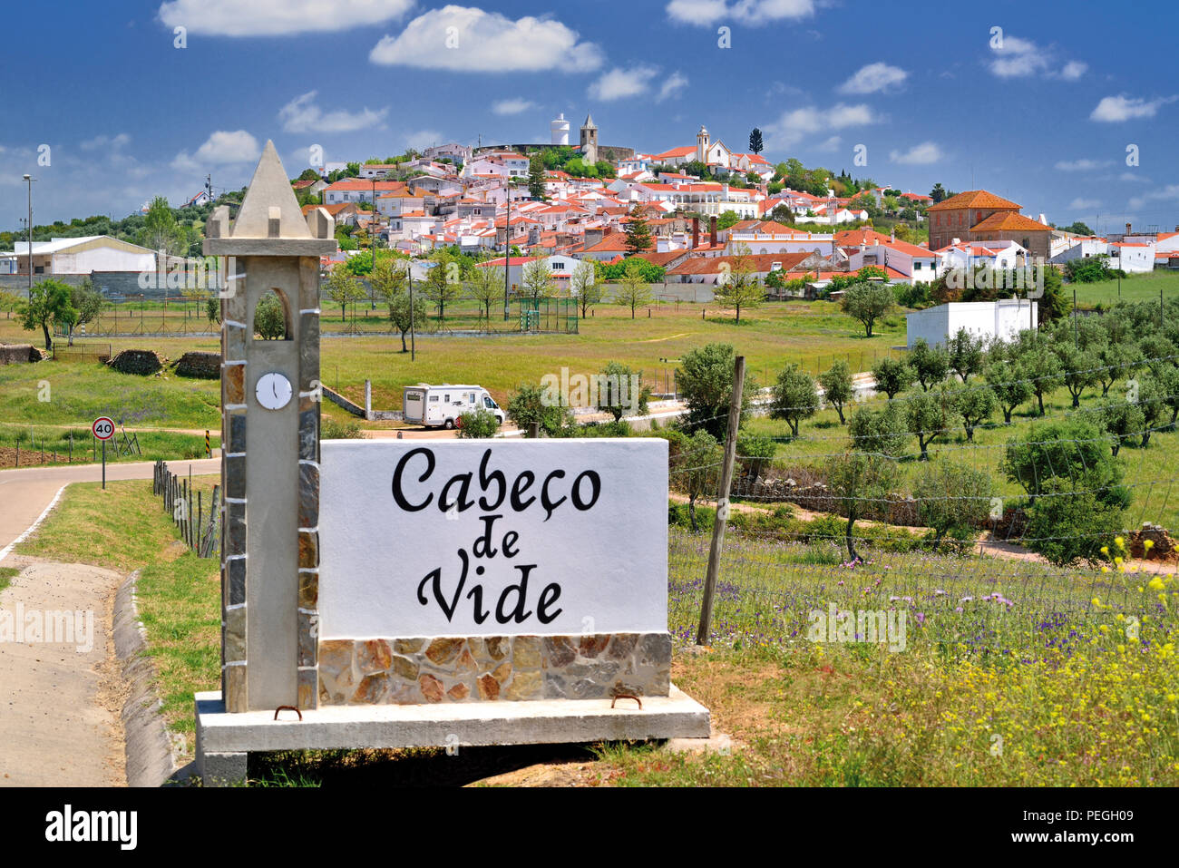 Eingang Signal in Form einer Kirche und Blick auf die idyllische Dorf Cabeco de Vide auf einem sanften grünen Hügel, umgeben von Olivenbäumen Stockfoto