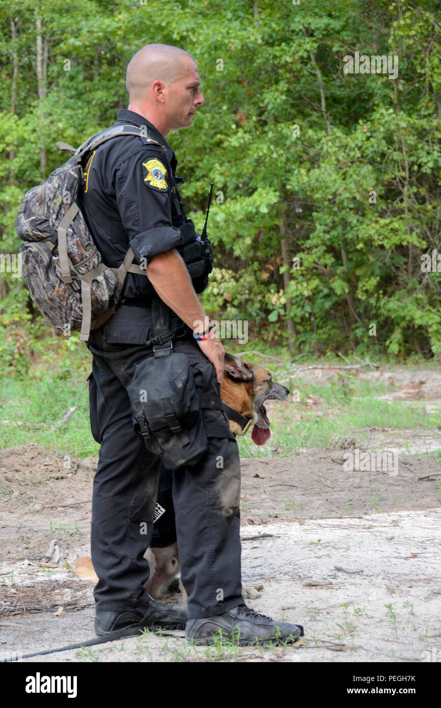 Das South Carolina Air National Guard Gastgeber einer Active shooter Übung mit Abteilung der Richland County Sheriff's an McEntire Joint National Guard, der Eastover, S.C., Aug 20, 2015 kombiniert. Die Ausübung Szenario einen Vorfall, wo bewaffnete Personen Eingang Punkte auf Basis angegriffen und aufgrund der begrenzten Personal an - Aufgabe beteiligt, Richland County reagierte mit K-9, SWAT und die Beseitigung von Explosivstoffen Einheiten zu unterstützen. Die ersthelfer die Angreifer durch die Wälder auf der Basis verfolgt und schließlich neutralisiert die Bedrohung. (S.C. Air National Guard Foto von Tech. Sgt. Caycee Watson/freigegeben) Stockfoto