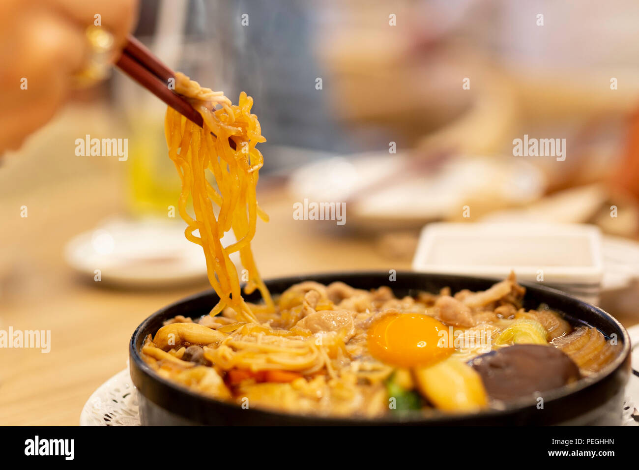 Hand mit Stäbchen Essen japanische Udon Nudeln mit Ei Stockfotografie -  Alamy