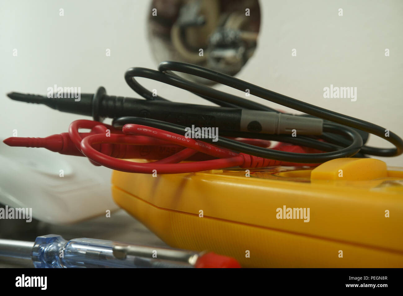 Werkzeuge für die Verkabelung einer elektrischen Steckdose auf dem Boden neben der Kunststoffabdeckung und freien Sockel zeigt interne Schaltkreise Stockfoto
