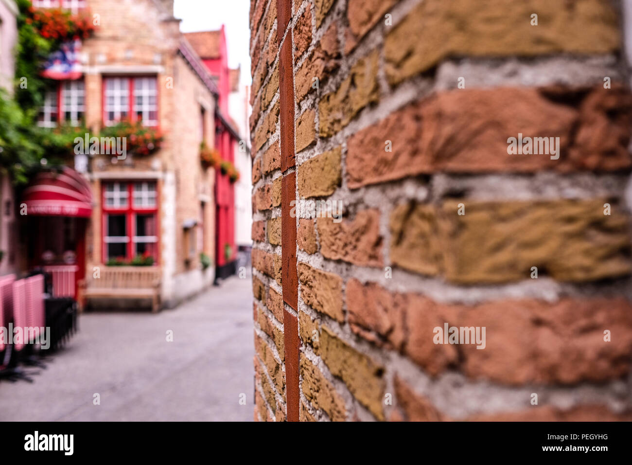 Landschaft Blick auf einer der Straßen von Brügge im Norden Belgiens, mit einer Mauer im Vordergrund und ein kleines Restaurant in verschwommenen Hintergrund Stockfoto