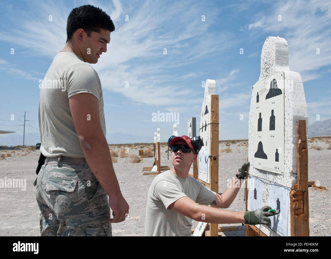 Ein Combat Arms Kursleiter gibt Feedback an einen Teilnehmer im M4 Gewehr Qualifikation Kurs an der 99th Sicherheitskräfte Squadron Combat Arms Schulung und Wartung Schießplatz auf der Nellis Air Force Base, Nev, Aug 18., 2015. Sich zu qualifizieren für die Treffsicherheit, Flieger, 17 der 24 Ziele schlagen und bis Experten, für die 22 der 24 Treffer erzielen. Stockfoto