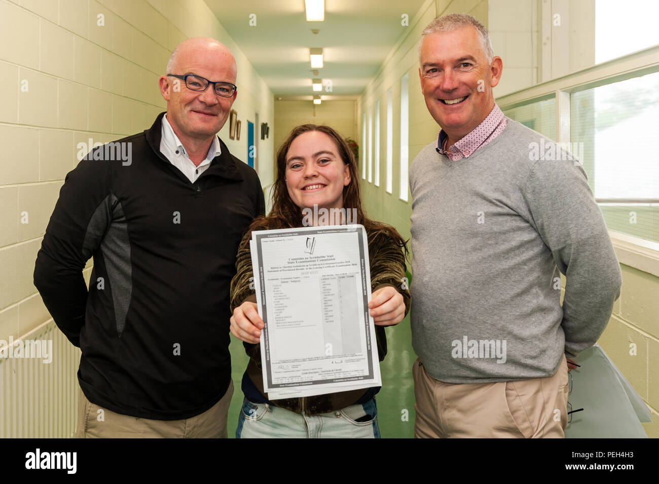 Schull, West Cork, Irland. August 2018. Die Studentin Mair Kelly scheint sehr glücklich zu sein, dass sie Cert Results verlassen hat. Sie ist mit dem Principal Brendan Drinan und dem Deputy Principal Padraig O'Sullivan abgebildet. Insgesamt 57,149 Studierende werden heute ihre Ergebnisse erhalten. Dies ist das zweite Jahr des neuen Grading-Systems, das bedeutet, dass es jetzt nur 8 Sorten gibt, statt 14 in den Vorjahren. Quelle: AG News/Alamy Live News. Stockfoto