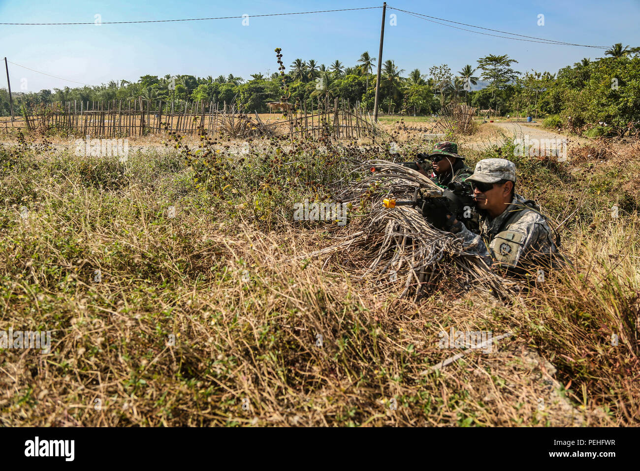 Us-Armee Sgt. Engel Cisneros, ein Infanterist vom Hauptsitz und Sitz Bataillon 2-27 th Infanterie Regiment, 3 Infanterie Brigade, 25 Infanterie Division, Post Sicherheit neben indonesische Soldaten vom 1.Infanterie Division von kostrad während Garuda Schild, Pacific Pathways 2015 Cibenda, West Java, Indonesien, Nov. 21, 2015. Garuda Shield ist eine regelmäßig geplante bilaterale Übung gesponsert von US-Army-Pacific, gehostet, die jährlich durch die Tentara Nasional Indonesia Armee der regionalen Sicherheit und Zusammenarbeit zu fördern. (U.S. Armee Foto von SPC. Michael Sharp / freigegeben) Stockfoto