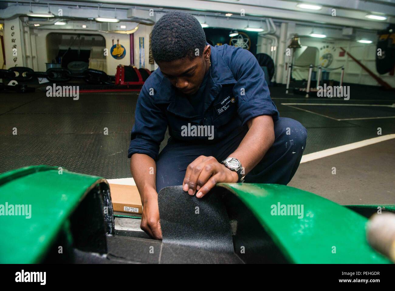 150822-N-DA 737-034 PAZIFISCHEN OZEAN (Aug. 22, 2015) - seaman Recruit Vincent Thomas, aus Dänemark, S.C., gilt für die Jagd Streifen auf einem hawse Rohr Abdeckung an Bord der USS John C Stennis (CVN 74). Seeleute aus dem John C Stennis Streik Gruppe sind, die sich einer Composite Trainingsgerät Übung und Joint Task Force Übung (COMPTUEX/JTFEX), der letzte Schritt bei der Zertifizierung zu implementieren. (U.S. Marine Foto von Mass Communication Specialist 3. Klasse Jonathan Jiang/Freigegeben) Stockfoto