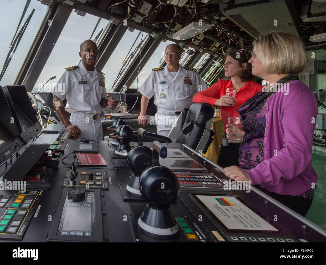 150827-N-MK 881-044 CHANGI NAVAL BASE (27. August 2015) Cmdr. Christopher Braun, kommandierender Offizier der Littoral Combat Ship USS Fort Worth (LCS 3) gibt eine Tour des Schiffes Colleen Gaydos, Mitte, und Jennifer Santos, rechts, beide Mitarbeiter mit der Senatskommission der Mittel Unterausschuss für Verteidigung. Derzeit auf einem 16 Monate rotational zur Unterstuetzung des Indo-Asia - Pazifik Nachjustieren, Fort Worth ist ein schnelles und agiles Kriegsschiff maßgeschneidert auf Patrouille in der Region und die Arbeit littorals Hull - Hull mit Partner Seestreitkräfte, die siebte Flotte mit der flexiblen Möglichkeiten Es muss n Stockfoto