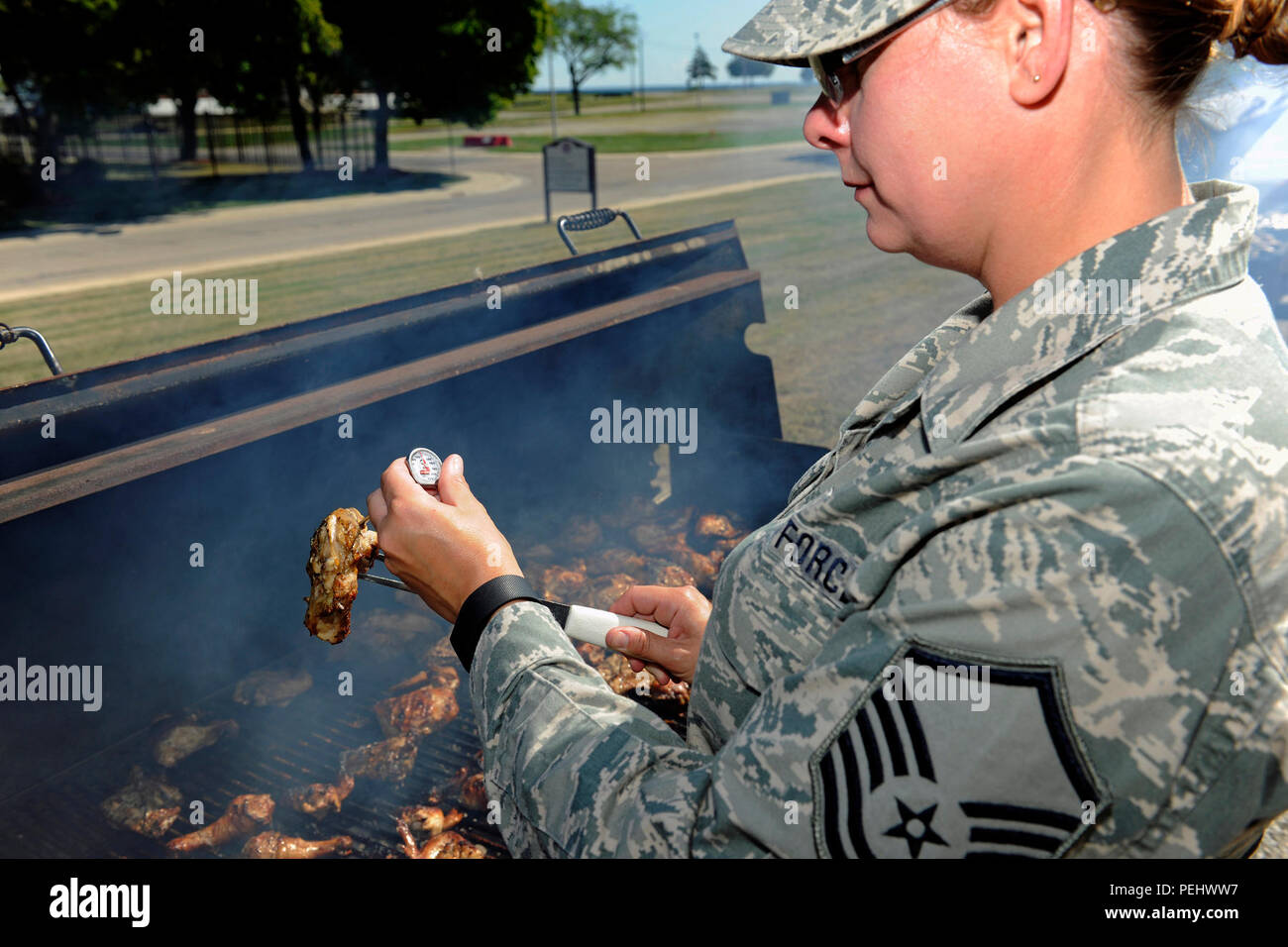 Master Sgt. Jennifer Trombetta der 127 Force Support Squadron, Selfridge Mich., ist zu überprüfen, ob das Huhn auf dem Grill voll während eines speziellen Food Services Koch bei Selfridge Air National Guard Base Mich., Nov. 1, 2015, in dem es gekocht wird. Der Koch ist ein Besondere jährliche Mittagessen, das von den Mitgliedern des FSS für die gesamte 127 Flügel vorbereitet. (U.S. Air National Guard Foto von Master Sgt. David Kujawa/Freigegeben) Stockfoto