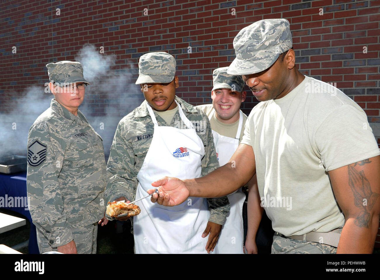 Mitglieder der 127 Force Support Squadron, Selfridge Mich., ist zu überprüfen, ob das Huhn auf dem Grill voll während eines speziellen Food Services Koch bei Selfridge Air National Guard Base Mich., Nov. 1, 2015, in dem es gekocht wird. Der Koch ist ein Besondere jährliche Mittagessen, das von den Mitgliedern des FSS für die gesamte 127 Flügel vorbereitet. (U.S. Air National Guard Foto von Master Sgt. David Kujawa/Freigegeben) Stockfoto