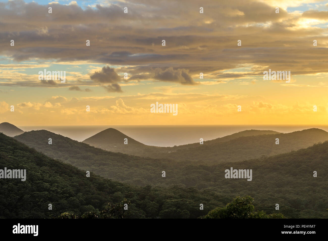 Hohe Aussicht über Berge gegen den Ozean und bewölkter Himmel Stockfoto