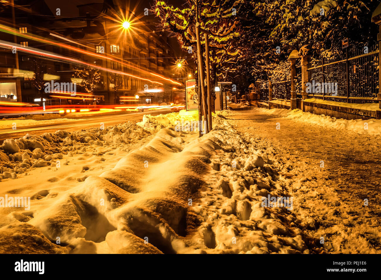 Lange Belichtung geschossen von den Straßen von Freiburg in der Schweiz, mit Schnee auf der Straße und Fahrzeug leichte Wanderwege im Hintergrund Stockfoto
