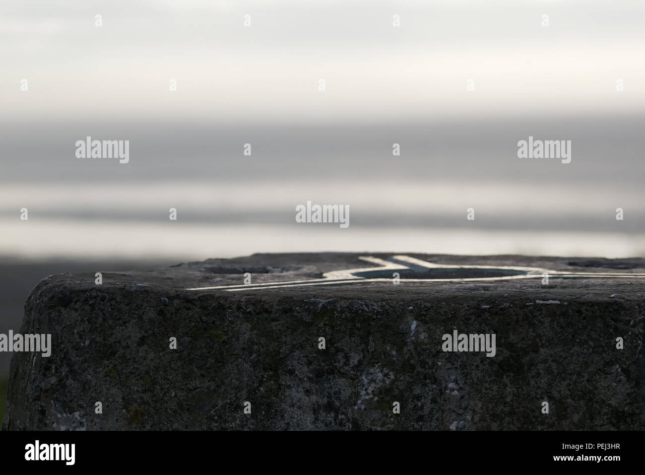 Trig Point in Sand Point, Somerset, mit Out of Focus Hintergrund Blick auf Meer Stockfoto