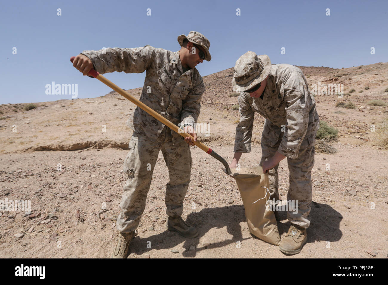 Südwest-Asien (24. August 2015) US Marine CPL William Bowling, links, und CPL. Tyler Thompson, rechts, füllen Sandsäcke um ihre Position während einer bilateralen Übung zu verstärken. Bowling ist ein Funker und Thompson ist ein vorwärts Beobachter mit Ostindien-Kompanie, Battalion Landing Team 3. Bataillon, 1. Marineregiment, 15. Marine Expeditionary Unit.  Die 15. MEU, an Bord der Schiffe der Essex amphibische Gruppe bereit, in Angriff genommen ist ein vorwärts-bereitgestellt, flexible seegestützte MAGTF zur Zusammenarbeit mit regionalen Partnern und Aufrechterhaltung der regionalen Sicherheit. (U.S. Marine Corps Foto von Sgt. Jamea Stockfoto