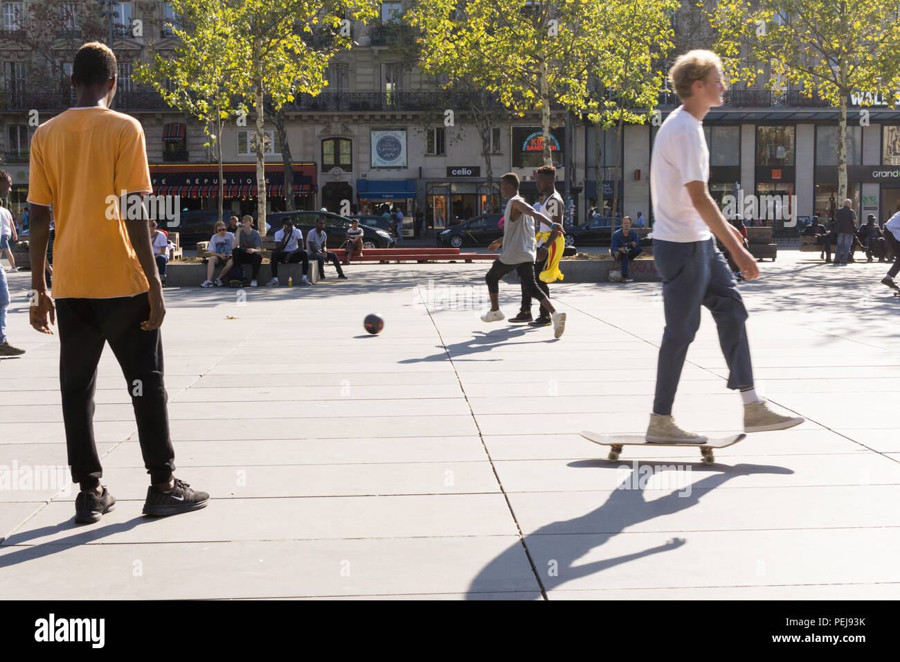 Street Scene auf dem Place de la Republique in Paris-skater Fahrten hinter den Jungs Fußball spielen. Frankreich. Stockfoto