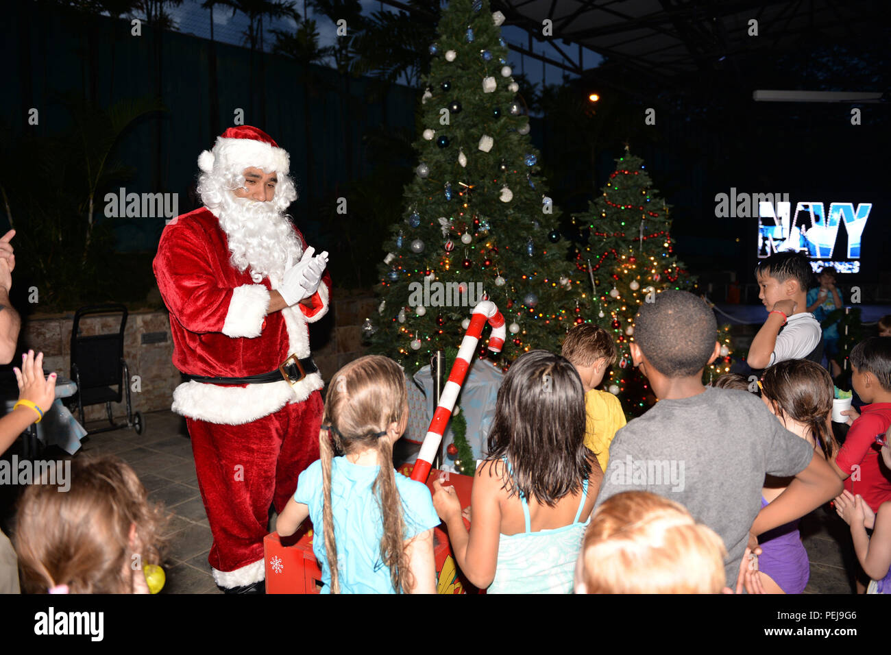 Singapur (31. 4, 2015) - Santa Claus, von Lt.Cmdr. Edward Cruz Matos, von Destroyer Squadron COMDESRON Sieben (7) begrüsst mit der Masse nach dem Anzünden die Weihnachtsbäume im Rahmen des jährlichen Marine Region Centre Singapore Weihnachtsbaum Beleuchtung Extravaganza, Dez. 4, 2015. Die Veranstaltung kamen mehr als 150 militärische Service Mitglieder, DoD Zivilisten und Familien. Die Veranstaltung wurde moderiert von NRC Moral, Wohlfahrt und Erholung und verschiedene Kunst und Kunsthandwerk Aktivitäten, Lebensmittel Lieferanten und Freiwilligen mit Backwaren und Eis - Schokolade Getränke und mehr. Darüber hinaus buchen Sie kostenlos Kinder Stockfoto