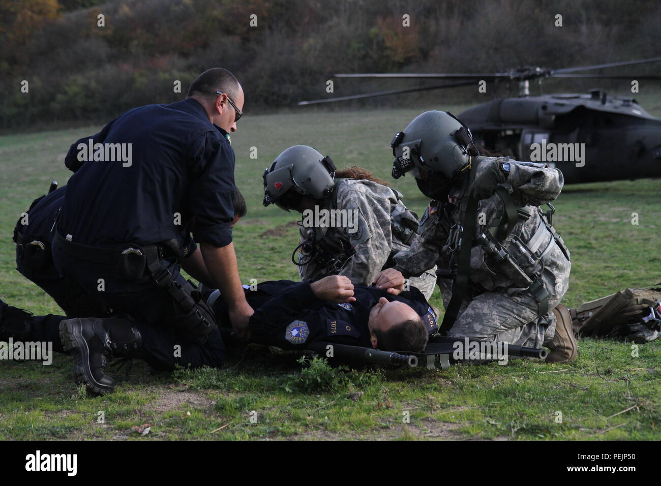 Us-Armee Sgt. Christine Vu und SPC. Jasmin Cardenas, sowohl Flug Mediziner F-Gesellschaft, 5.BATAILLON, 159 Aviation Regiment, aus Clearwater, Fla., bereiten Sie eine simulierte Kosovo Grenzpolizei Patienten während eines medevac Ausbildung übung auf der Verwaltungsgrenze zwischen Kosovo und Serbien, November 12, 2015, in Rogagic, Kosovo einen Hubschrauber zu bewegen. KFOR, Peace Support Mission der NATO in der Region seit 1999, ist zu Beginn des KBP Personal in ABL-Patrouillen als Teil ihrer Mission, Sicherheit und die Freiheit der Bewegung im Kosovo gewährleistet zu integrieren. Die Klassen in Wurf trägt und Stockfoto