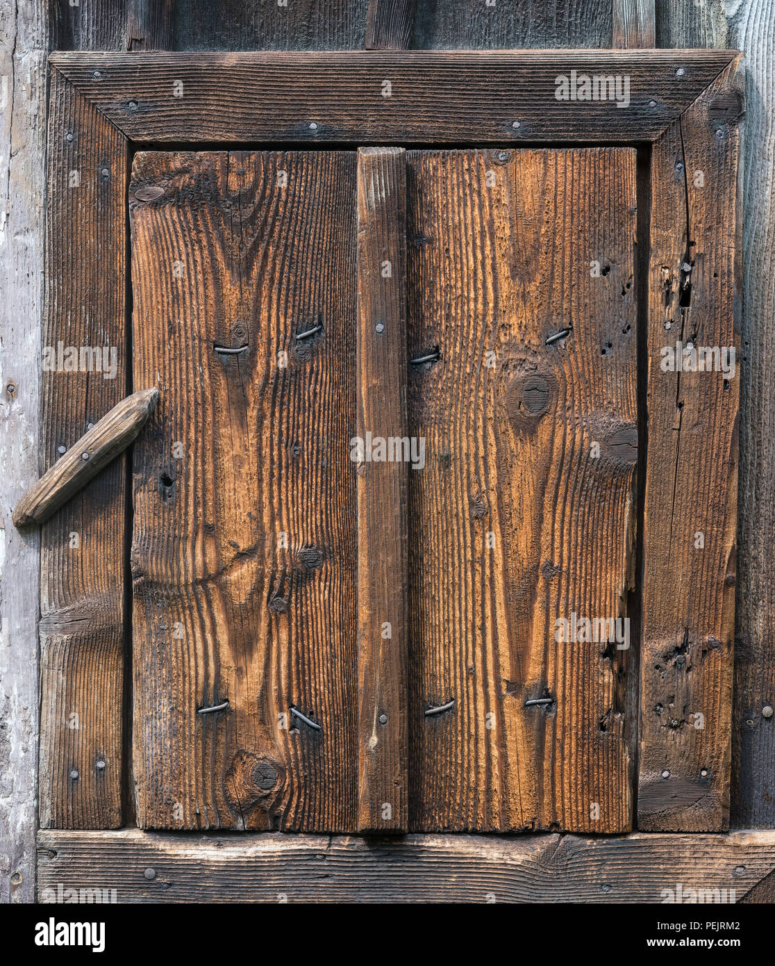 Geschlossene Holz- rustikalen Wicket, Revolvierenden sperren. Kleine ländliche Tür. Grob strukturierte Holz, Nägel, Knoten. Dorf Hintergrund des Jahrgangs Planken, Rahmen, fangen. Stockfoto