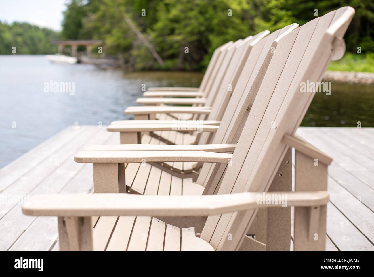 Seitenansicht der Muskoka Stühle auf einem Dock. Stockfoto