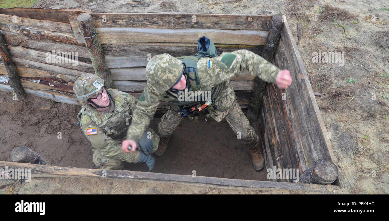 Ein fallschirmjäger mit der 173Rd Airborne Brigade (links), Trainer und Uhren der Soldat mit dem ukrainischen Land Kräfte (rechts), 10.12.2015, während der Ausbildung auf, wie man eine Handgranate als Teil von Fearless Guardian II an der internationalen Friedenssicherung Security Center beschäftigen. Soldaten, die in der ukrainischen Armee lernen, wie sie die ordnungsgemäße Griff anwenden und Wurftechniken, die Sicherheits- und Vorsichtsmaßnahmen. . (U.S. Armee Foto: Staff Sgt. Adriana M. Diaz-Brown, 10 Drücken Sie Camp Headquarters) Stockfoto