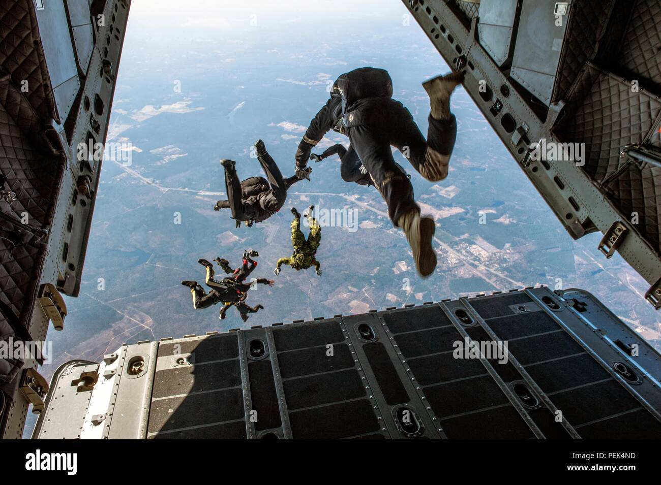 Die Mitglieder der U.S. Army Parachute Team, die schwarzen Ritter, der U.S. Army Special Operations Command Parachute Team, das Schwarze Dolche und Niederländischen Jumpmasters eine militärische freien Fall airborne Operation aus einer C-27 Verhalten im Betrieb Spielzeug Drop in Camp Mackall, N.C., 10.12.2015. Gehostet von US-Armee die zivilen Angelegenheiten & psychologische Operations Command (Airborne), Operation Spielzeug Drop ist der weltweit größte kombinierten Betrieb mit sieben Partner - nation Fallschirmjäger teilnehmenden und Soldaten erlaubt, die Möglichkeit, Kindern in Not zu helfen, überall Spielwaren für den Urlaub erhalten. (U.S. Armee Stockfoto