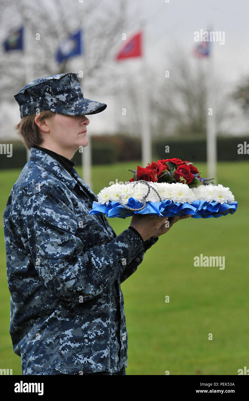 U.S. Navy Seaman Sydney, US Africa Command division Analyst, hält einen Kranz konzipiert als Anker der gefallenen Helden von Pearl Harbor während der 74Th Pearl Harbor Gedenkfeier an RAF Molesworth, Großbritannien, 7. Dezember 2015 zu Ehren. Pearl Harbor Überlebenden, ehemalige Marine Sgt. John Egan und US-Armee Oberst Mark Kjorness, USAFRICOM Joint intelligence Director, trat in Sydney Ehrenkompanie der Kranz, nachdem es platziert wurde. (U.S. Air Force Foto: Staff Sgt. Ashley Tyler/Freigegeben) (Name aus Sicherheitsgründen entfernt) Stockfoto