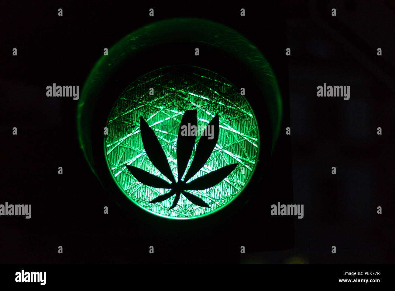 Ein Aufkleber einer Anlage auf eine grüne Ampel als Symbol für die  Legalisierung von Cannabis oder Marihuana Stockfotografie - Alamy
