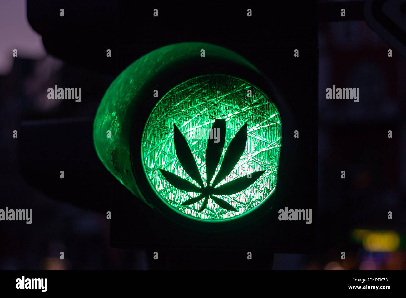 Ein Aufkleber einer Anlage auf eine grüne Ampel als Symbol für die  Legalisierung von Cannabis oder Marihuana Stockfotografie - Alamy