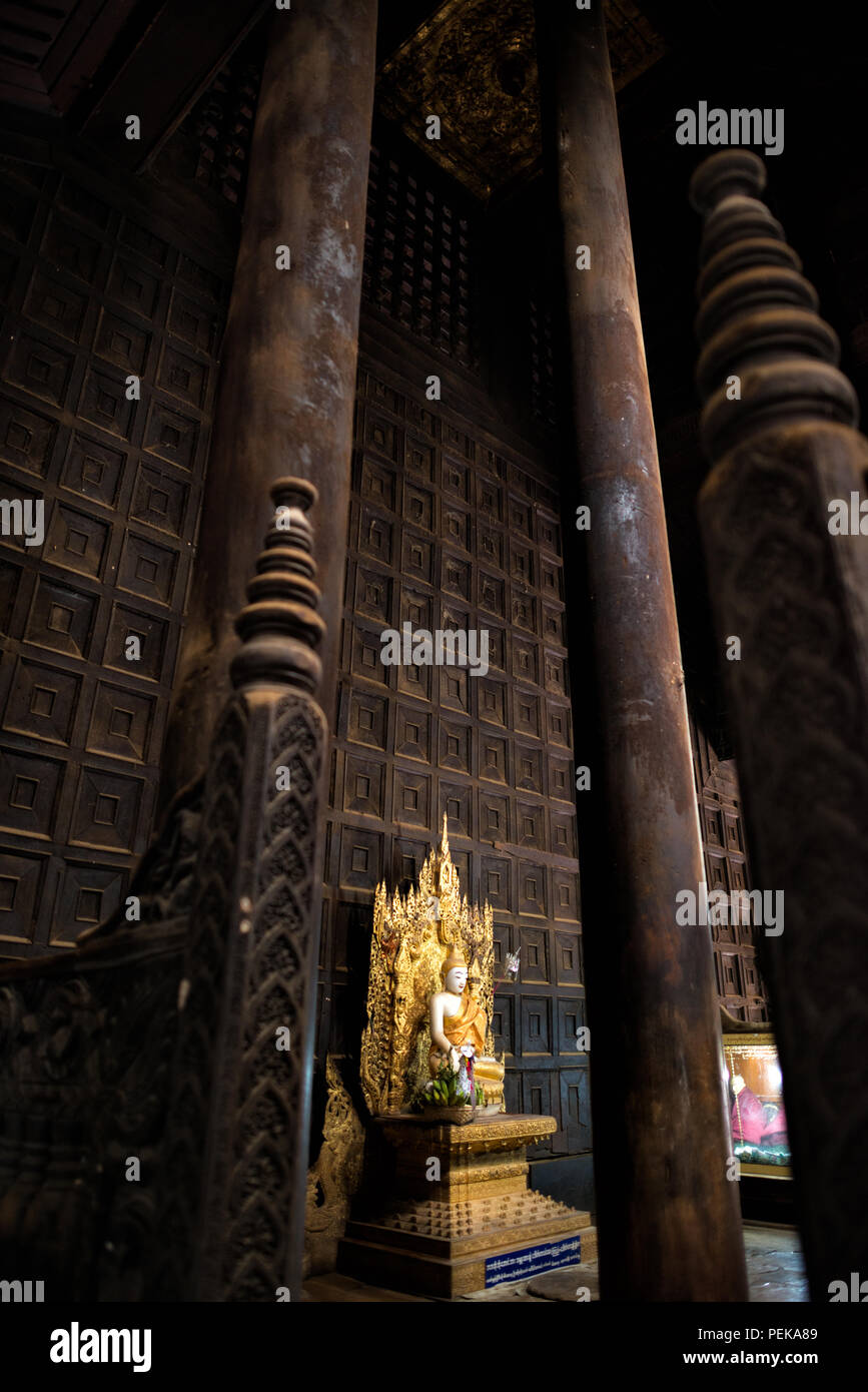 INWA (AVA), Myanmar - der Hauptaltar und Schrein des Bagaya-Klosters in Inwa, Myanmar. Das Kloster, auch bekannt als Bagaya Kyaung, wurde 1834 während der Herrschaft von König Bagyidaw erbaut. Er besteht vollständig aus Teakholz, mit 267 riesigen Teakholzpfählen, von denen der größte 60 m hoch und 9 m Umfang ist. Es liegt in der alten königlichen Hauptstadt von Inwa (Ava), nicht weit von Mandalay. Stockfoto