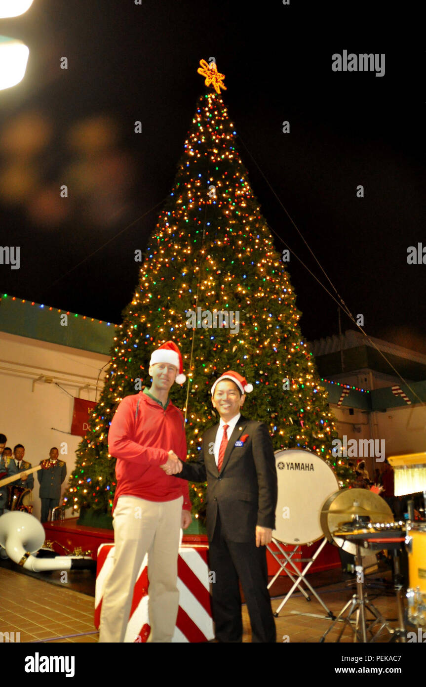 Oberst Christopher A. Feyedelem, Links, schüttelt Hände mit Urasoe Stadt Bürgermeister Tetsuji Matsumoto während des Camps Kinser Christmas Tree Lighting Ceremony Nov. 27 an Bord Camp Kinser, Okinawa, Japan. Hunderte von Teilnehmern aus allen Einheiten auf Kinser und Kinder aus verschiedenen Organisationen wie Pfadfinder und Pfadfinderinnen von Amerika im Falle teilgenommen. Feyedelem ist der kommandierende Offizier der Zentrale Regiment, 3. Marine Logistics Group, III Marine Expeditionary Force. (Foto mit freundlicher Genehmigung von Toshi Nakamoto) Stockfoto