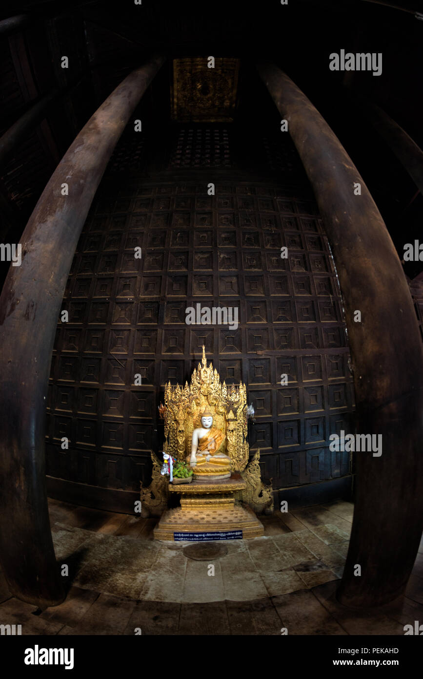 INWA (AVA), Myanmar - der Hauptaltar und Schrein des Bagaya-Klosters in Inwa, Myanmar. Das Kloster, auch bekannt als Bagaya Kyaung, wurde 1834 während der Herrschaft von König Bagyidaw erbaut. Er besteht vollständig aus Teakholz, mit 267 riesigen Teakholzpfählen, von denen der größte 60 m hoch und 9 m Umfang ist. Es liegt in der alten königlichen Hauptstadt von Inwa (Ava), nicht weit von Mandalay. Stockfoto