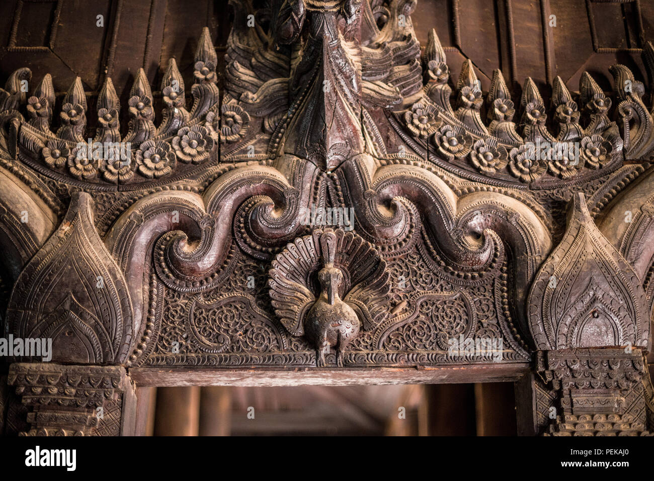 INWA (AVA), Myanmar – komplexe Holzschnitzereien in Teakholz schmücken das Bagaya-Kloster in Inwa, Myanmar. Das Kloster Bagaya (auch bekannt als Bagaya Kyaung) wurde 1834 während der Herrschaft von König Bagyidaw erbaut. Er besteht vollständig aus Teakholz, mit 267 riesigen Teakholzpfählen, von denen der größte 60 m hoch und 9 m Umfang ist. Es liegt in der alten königlichen Hauptstadt von Inwa (Ava), nicht weit von Mandalay. Stockfoto