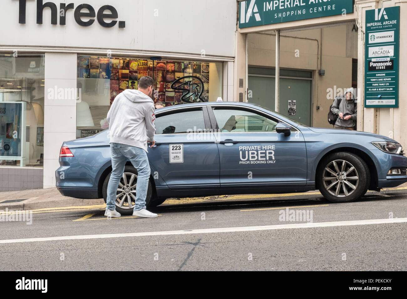 Der Mensch nimmt Uber Taxi minicab Fahrt mit einem UK Street. Stockfoto