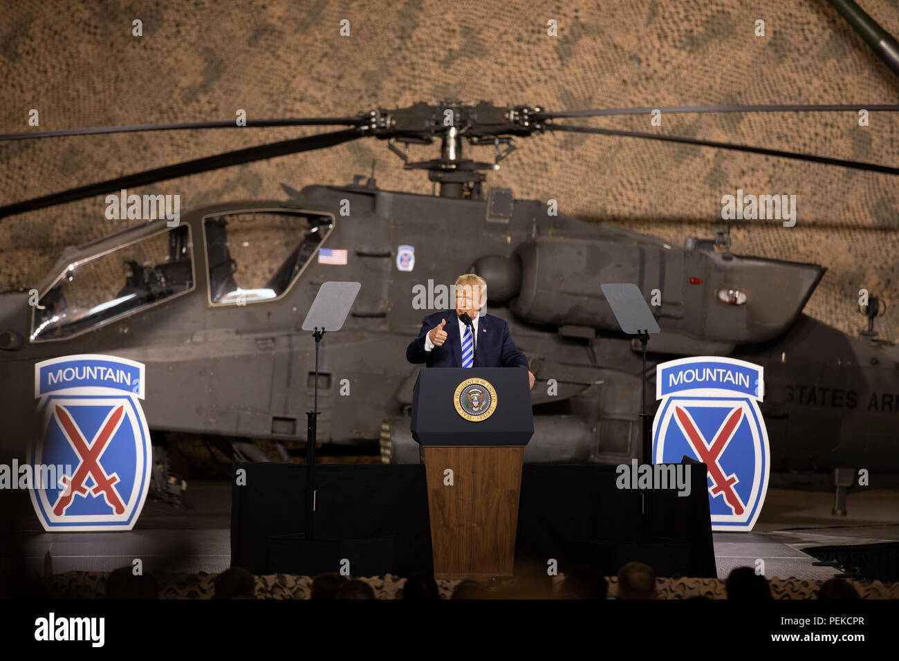 Us-Präsident Donald Trump Adressen Soldaten aus dem 10 Mountain Division von vor ein Apache Kampfhubschrauber bei einem Besuch der John McCain National Defense Authorization Act, den 13. August in Fort Drum, New York 2018 zu unterzeichnen. Stockfoto