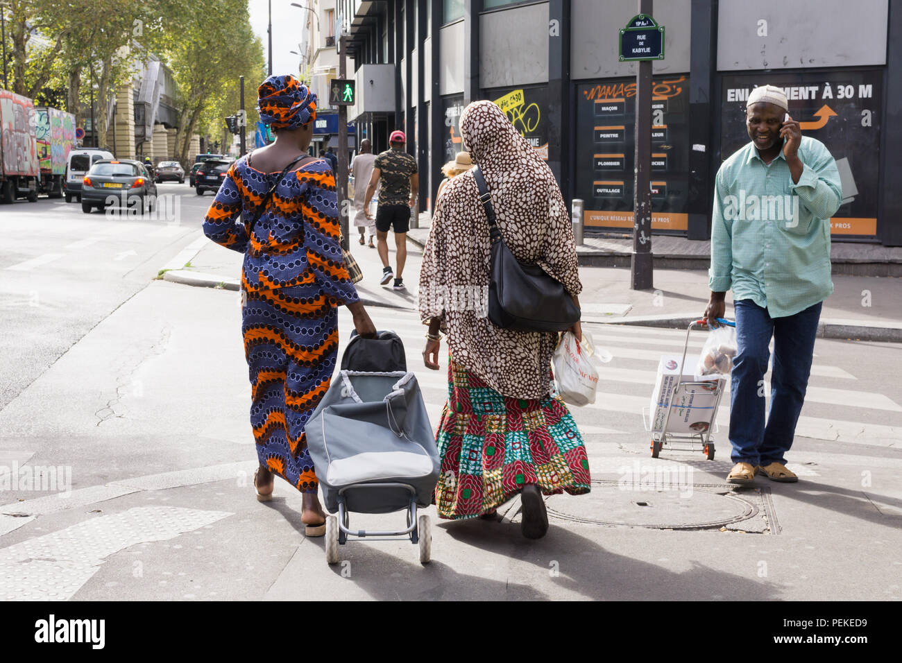 Eine Straßenszene in der stalingrad Gegend von Paris - Frauen afrikanischer Herkunft in traditioneller Kleidung wandern und Plaudern. Frankreich. Stockfoto
