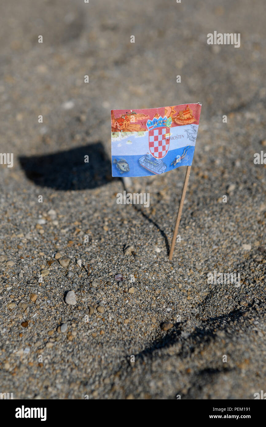 Touristische Flagge von Kroatien in Sand abgeholt am Strand, verschiedene Reiseziele und Karte von Kroatien über Flagge bedruckt, cocktail Flagge Stockfoto