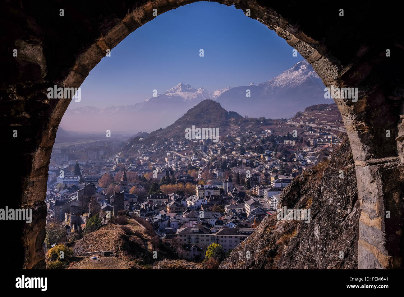 Querformat der Stadt Sion im Wallis, Schweiz, aus dem Castel der Tourbillon, mit schneebedeckten Alpen im Hintergrund Stockfoto