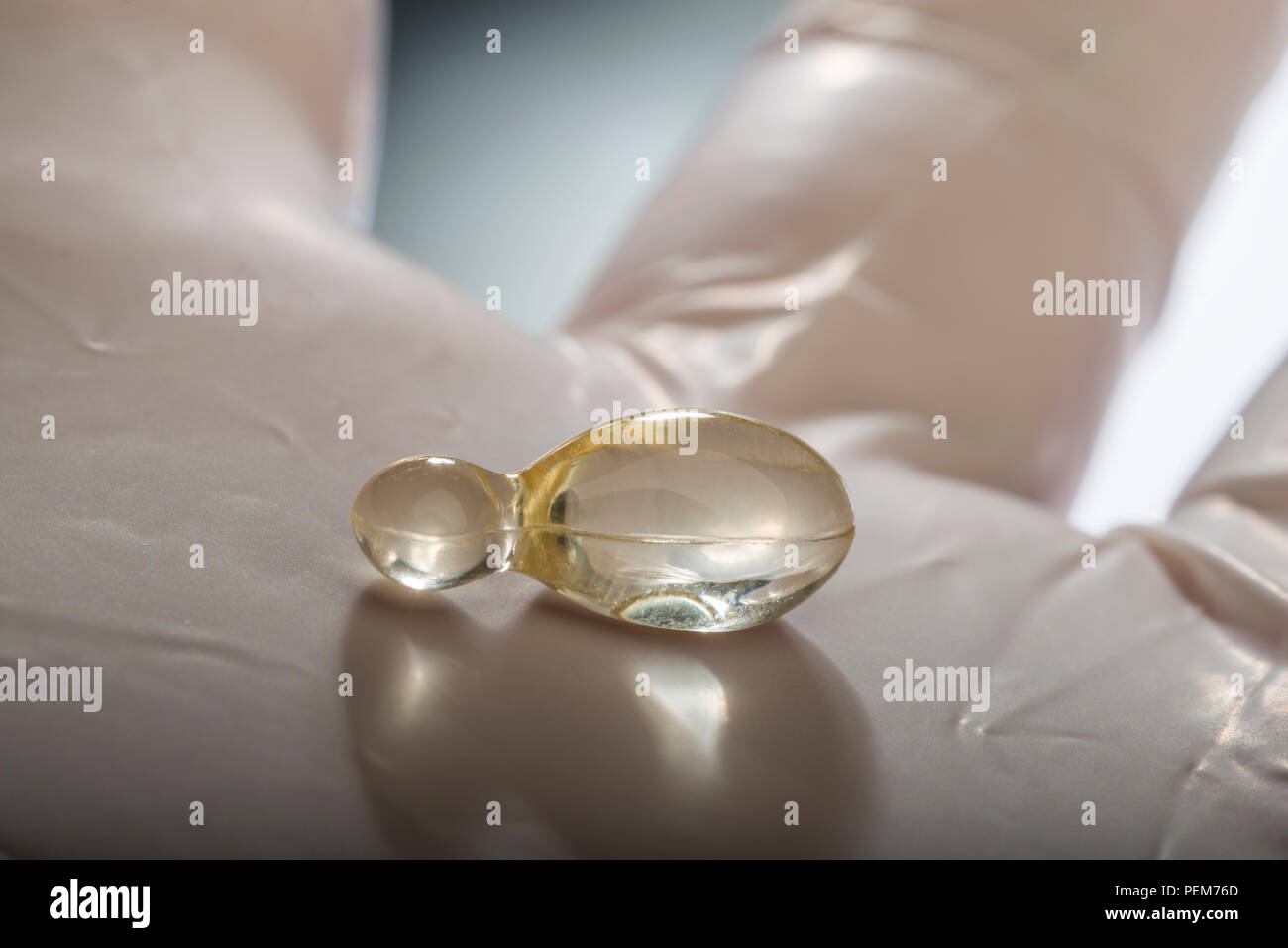 Hand mit Handschuh hält Gel Kapseln Stockfoto