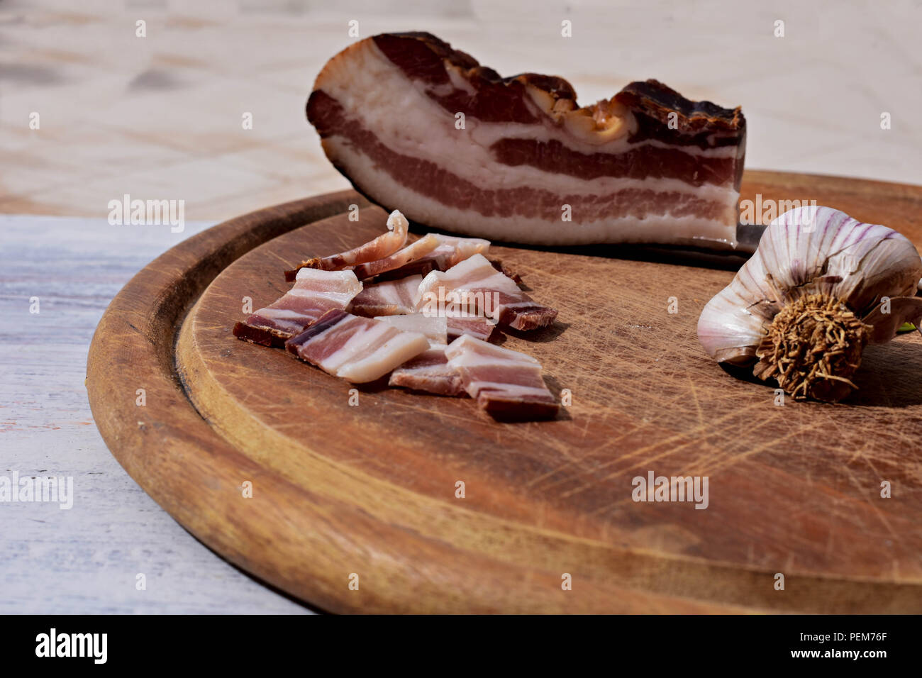 Leckeren Teller mit geräuchertem Speck, Knoblauch und Brot mit rustikalen Holzmöbeln Hintergrund/Traditionelle Balkan Essen Stockfoto