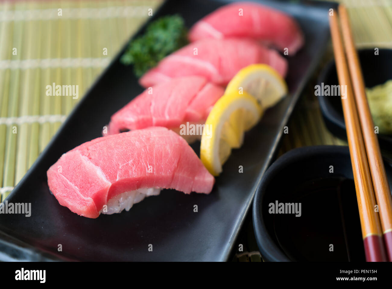 Otoro Thunfisch Sushi auf schwarze Platte zusammen mit japanischen Sauce und green leaf Dekoration, Japanisches Essen, Sushi zu schließen. Stockfoto