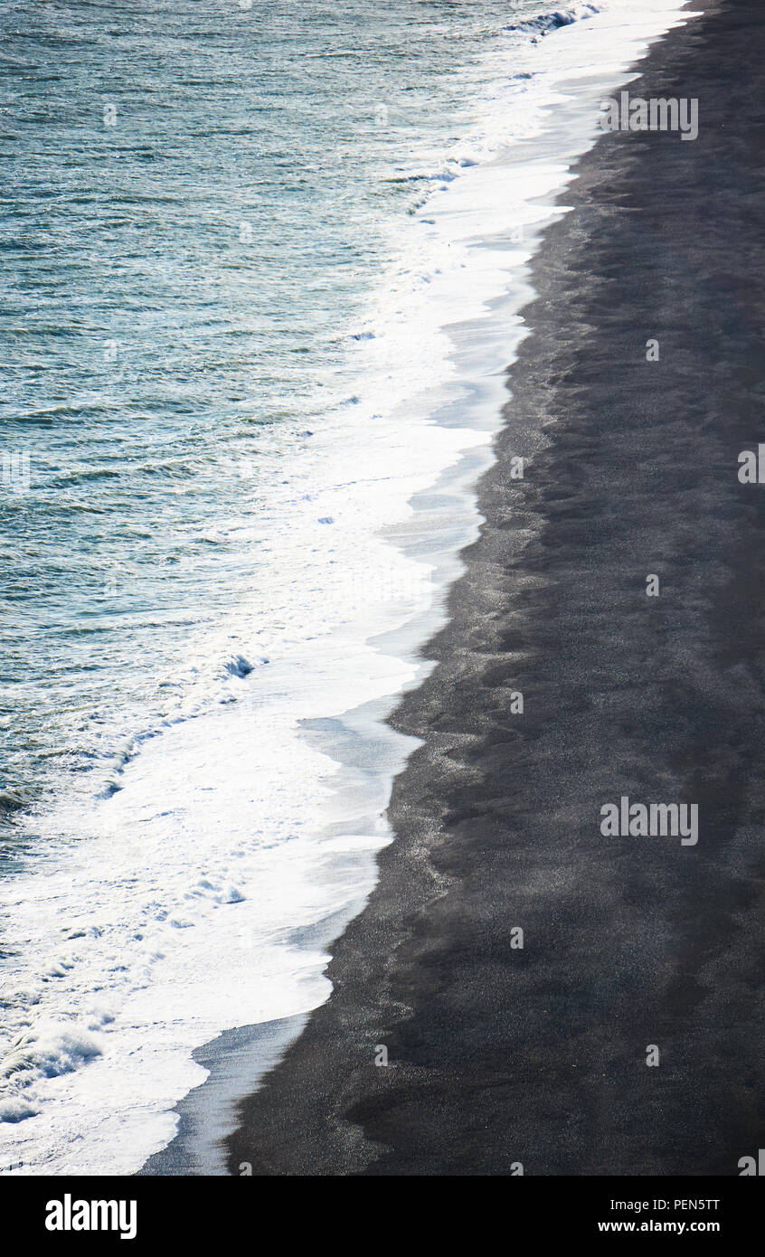 Isländischen Küste. Island schwarzem Sand. Ozean und schwarzem Sand Küste. Geometrie Küstenlinie in vertikalen Foto. Weiße Wellen. Vik, Island. South Island la Stockfoto