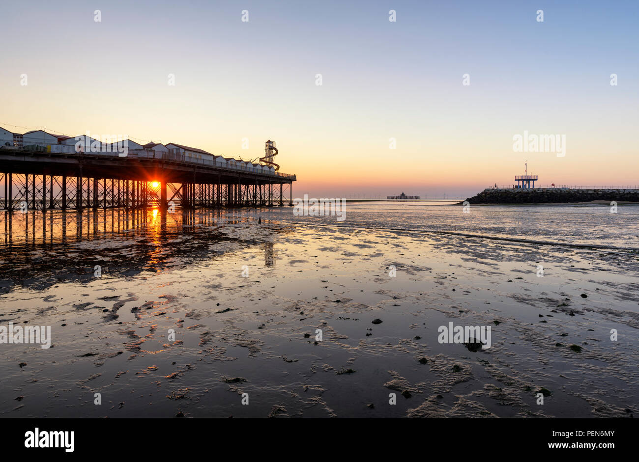 Sonnenuntergang pokes durch Lücken in Herne Bay Pier an der Küste von Kent. Anzeigen von Herne Bay pier, Arm Neptuns und der alte Pier. Stockfoto