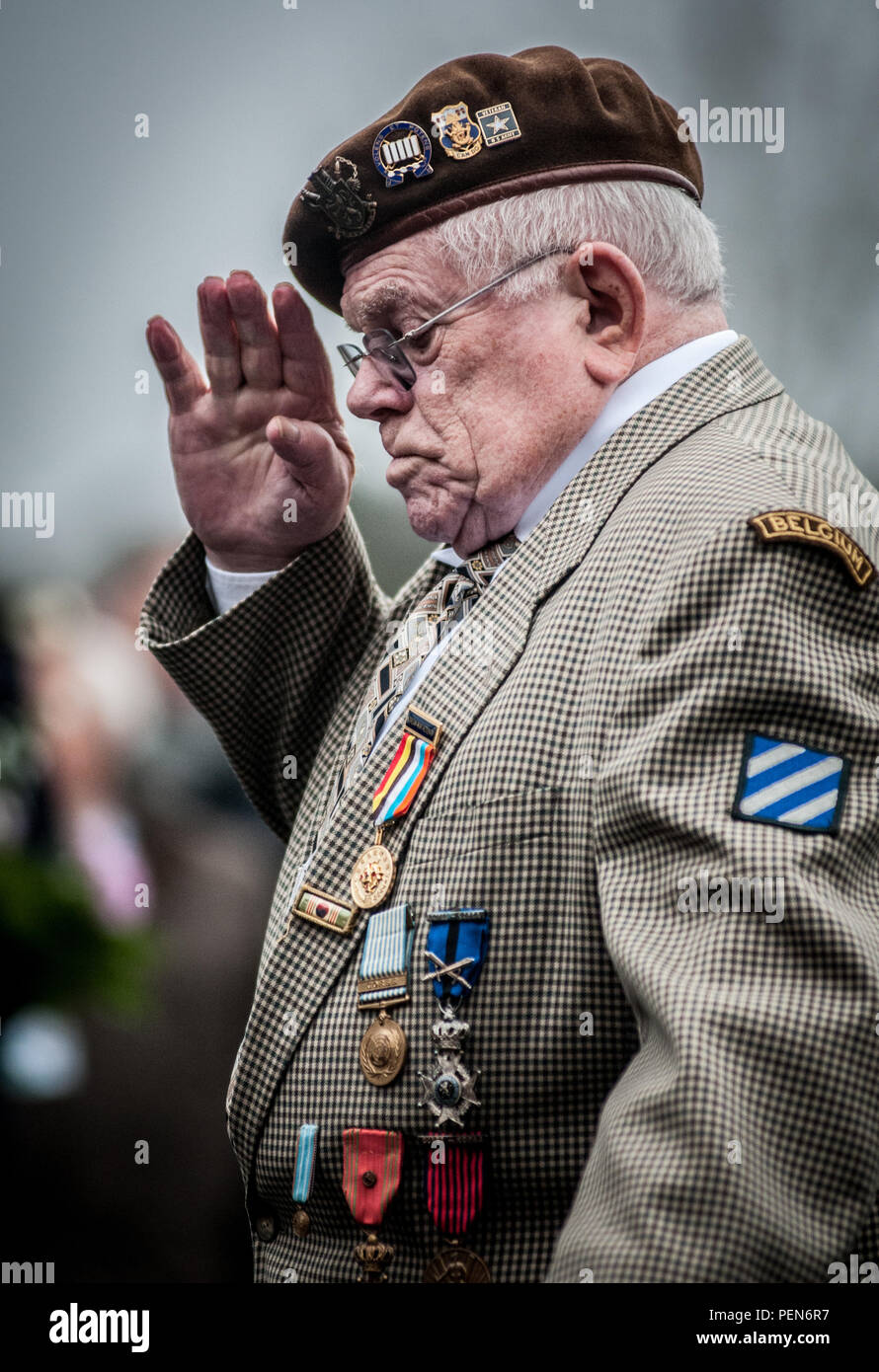 Ein ehemaliger belgischer Soldat begrüßt Während einer Gedenkveranstaltung an der General George Patton Memorial in Bastogne, Belgien, während einer Feier zum 71. Jahrestag der Schlacht der Ausbuchtung, Dez. 12, 2015 zu erkennen. Das Denkmal ist zu Patton für das Brechen der Belagerung von Bastogne, die merceny Platz steht. (U.S. Armee Fotos von Staff Sgt. Bernardo Fuller/Freigegeben) Stockfoto