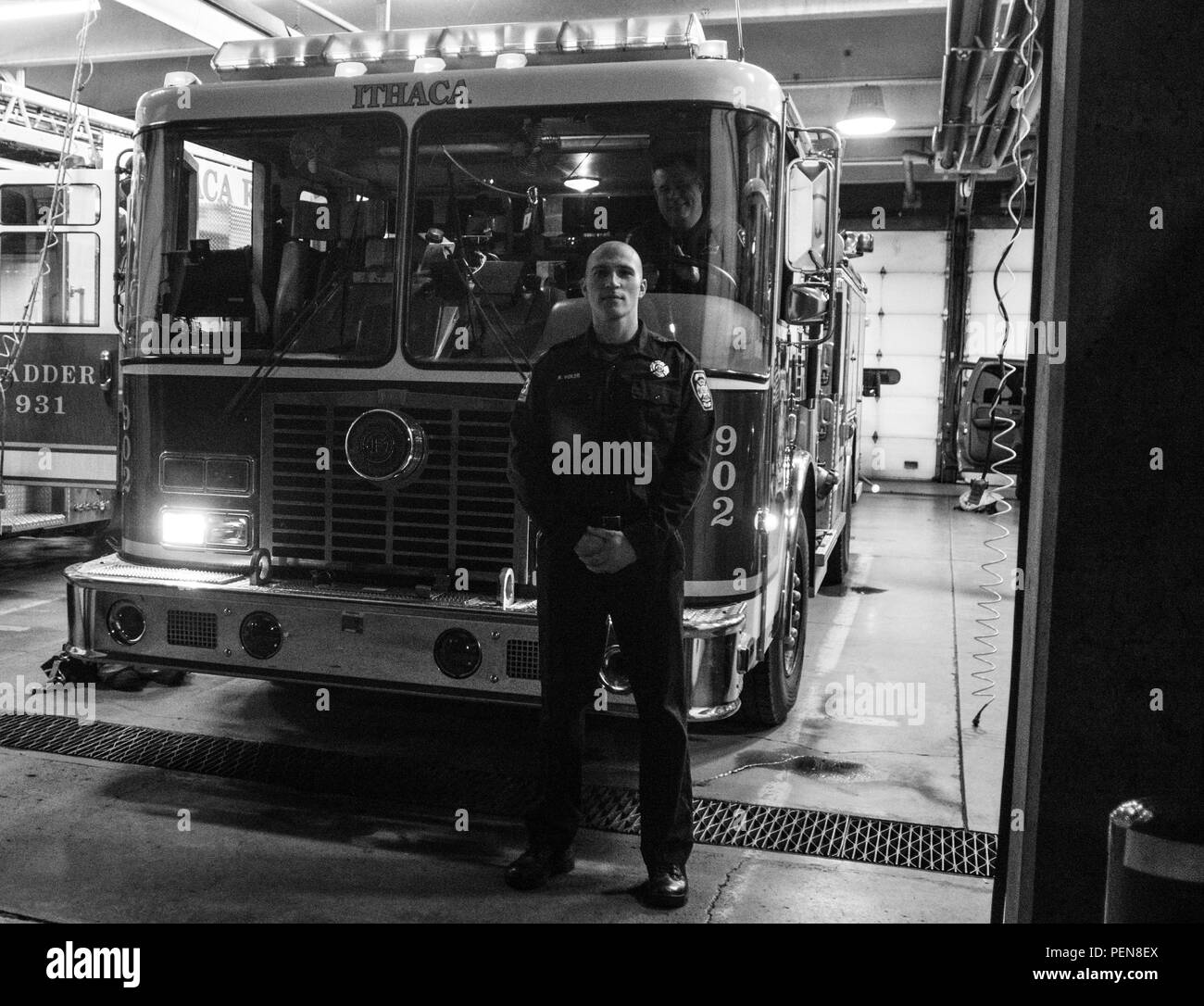 Staff Sgt. Russell Vidler, 98th Abteilung Weiterbildung (IET) Drill Sergeant des Jahres, posiert für ein Foto vor dem Motor 902 als Fellow Feuerwehrmann Peter Snell Peers auf Central Station in Ithaca, N.Y., Dez. 18, 2015. Vidler hat für die Stadt Ithaca als Feuerwehrmann für zwei Jahre gearbeitet und dient als Unteroffizier mit der Armee finden. (U.S. Armee Foto von Sgt. 1. Klasse Brian Hamilton) Stockfoto