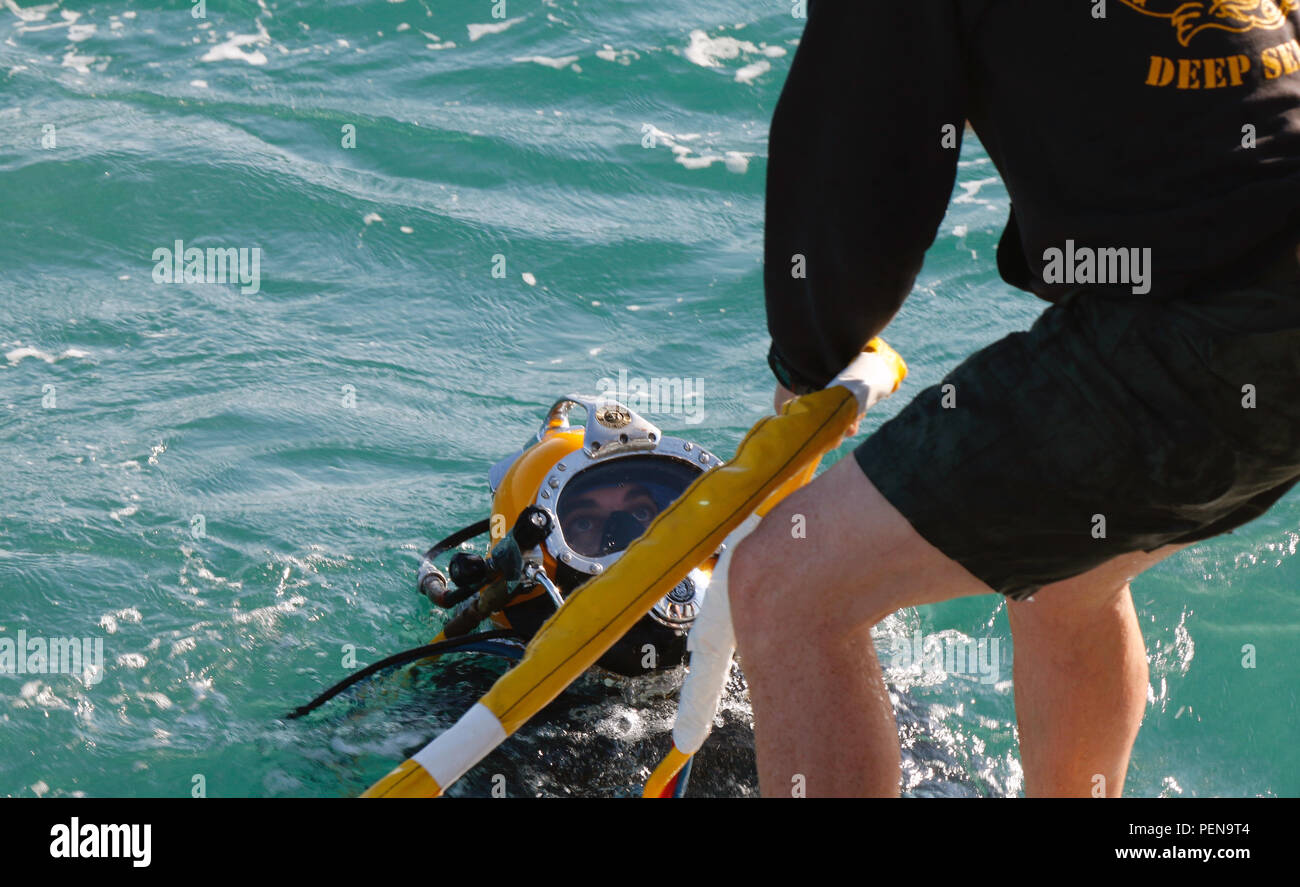 Ein dive Supervisor mit der 74Th Engineer Dive Loslösung, hilft ein Taucher aus dem Wasser während ihrer jährlichen Deep Blue Training vor der Küste von Kuwait, Dez. 2. Der primäre Fokus des Trainings war es, zu bewerten und zu verwalten Kenntnisse auf allen taucherischen Fähigkeiten durch die Oberfläche Tauchen, Scuba und Druckkammer Operationen. (Foto von USARCENT Public Affairs Staff Sgt. Jared Crain) Stockfoto