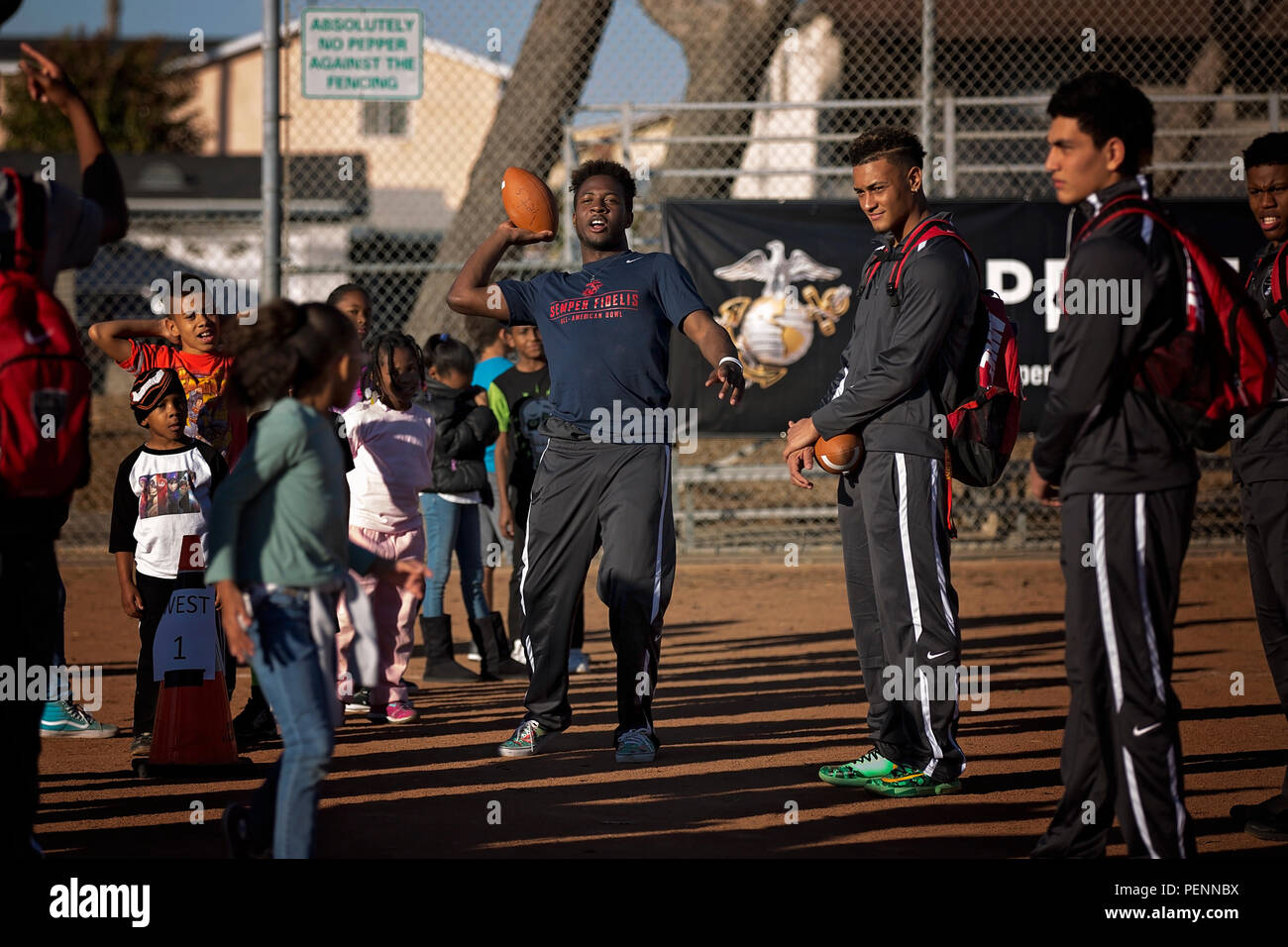 Jared Mayden wirft einen Fußball zu einem Kind aus der Gemeinschaft während des Mentorings Aktivität bei Sports Complex Veteran's, Carson, Calif., 31.12.2015. Die Athleten und Marines lehrte die Kinder den Wert der guten Sportsgeist, Führung und Gesundheit und Wellness. Mayden ist cornerback von Sachse High School, Sachse, Texas. (U.S. Marine Corps Foto von Sgt. Rebecca Eller) Stockfoto