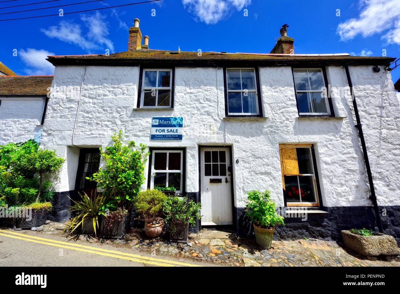 Haus zum Verkauf mit Brettern vernagelt, kaputtes Fenster, Fowey, Cornwall, England, Großbritannien Stockfoto