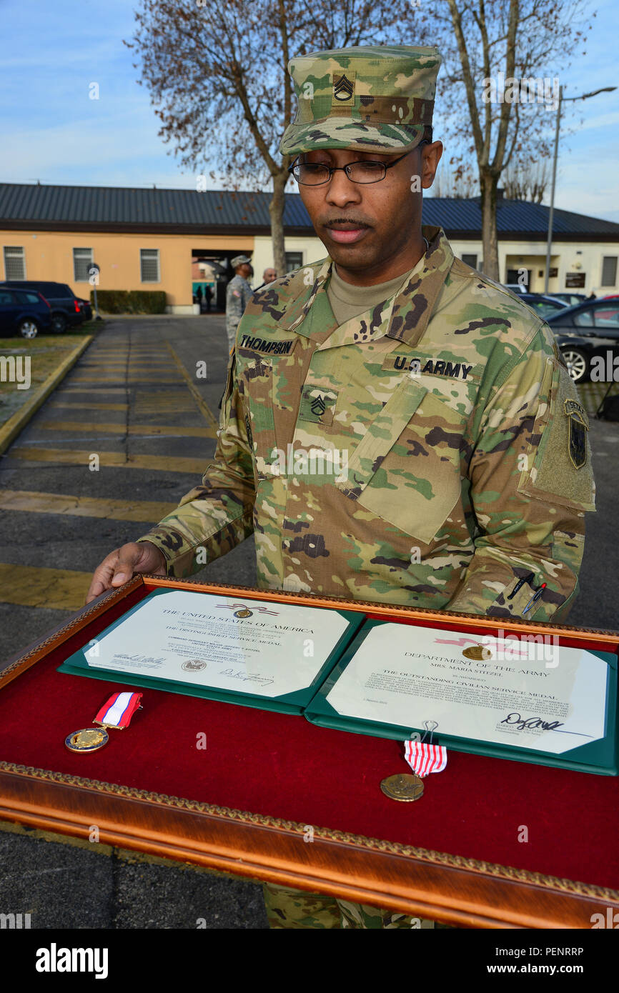 Die US-Armee Afrika Soldat bereitet Auszeichnungen und Medaillen für Command Sgt. Maj. Jeffery Stitzel, U.S. Army Africa Command Sergeant Major, und seine Frau während der Siegerehrung bei Carlo Caserma Ederle in Vicenza, Italien, Jan. 8, 2016. (U.S. Armee Foto von visuellen Informationen Spezialist Paolo Bovo/Freigegeben) Stockfoto