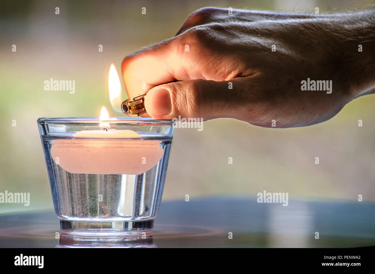 Hand Mit Einem Feuerzeug Eine Kerze Anzunden Schwimmend Im Wasser Stockfotografie Alamy