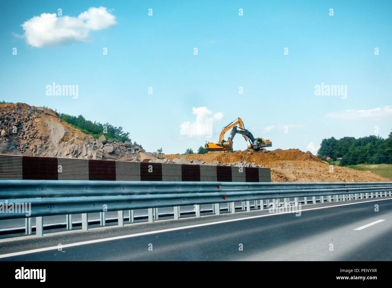 Zwei schwere, gelb und schwarz Bagger auf der Baustelle Verschieben von Boden und Fels, Autobahn, Straßenbau, Ausleger sind gekreuzt Stockfoto